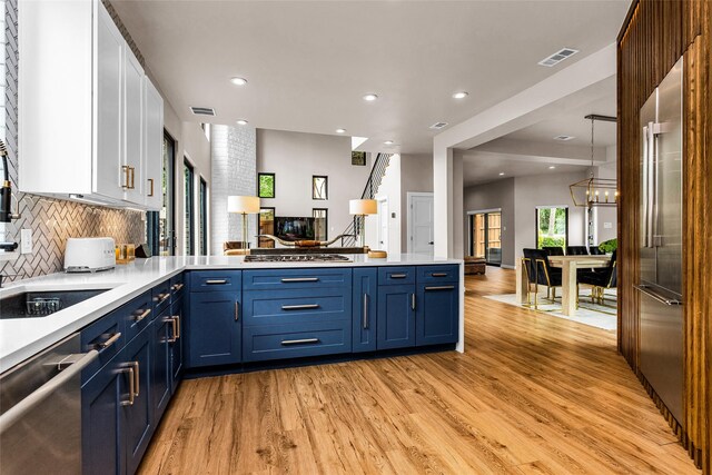2856 Peninsula Dr, Grapevine, TX 76051 - kitchen featuring stainless steel appliances, blue cabinetry, visible vents, and a peninsula