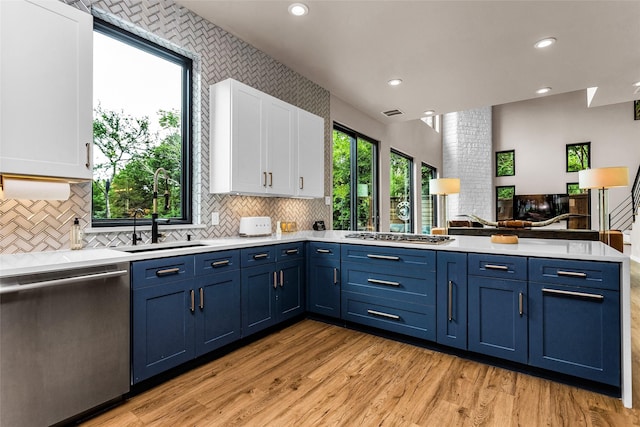 2856 Peninsula Dr, Grapevine, TX 76051 - kitchen with a peninsula, white cabinetry, a sink, appliances with stainless steel finishes, and blue cabinetry