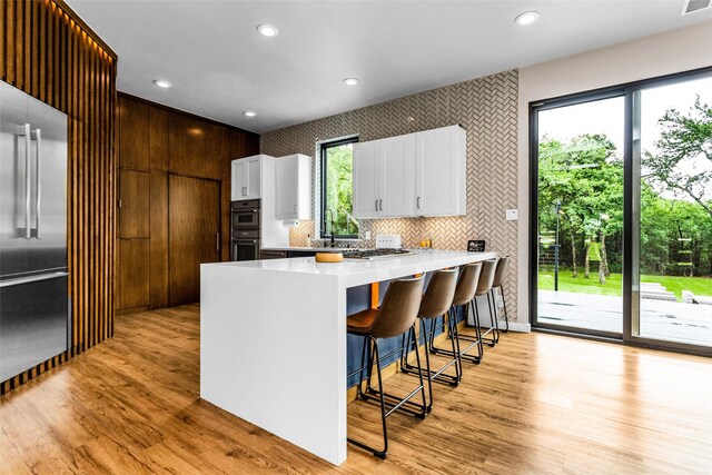 2856 Peninsula Dr, Grapevine, TX 76051 - kitchen with plenty of natural light, light wood-style flooring, white cabinetry, and built in fridge