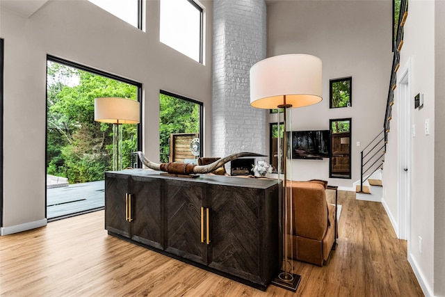2856 Peninsula Dr, Grapevine, TX 76051 - living room featuring light wood-style floors, baseboards, a high ceiling, and stairs