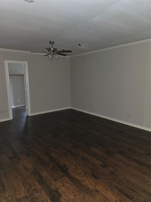 empty room with ornamental molding, a ceiling fan, and dark wood-type flooring