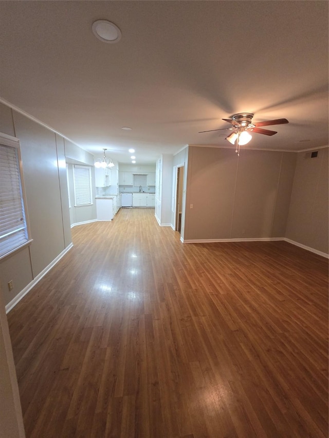 unfurnished living room with baseboards, ceiling fan with notable chandelier, and wood finished floors