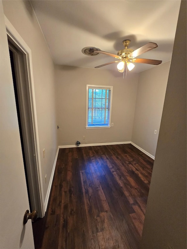 spare room featuring a ceiling fan, baseboards, and wood finished floors