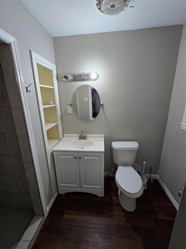 full bath featuring vanity, baseboards, toilet, and wood finished floors