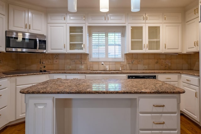 2103 Juanita Dr, Arlington, TX 76013 - kitchen with black electric cooktop, stainless steel microwave, and white cabinetry