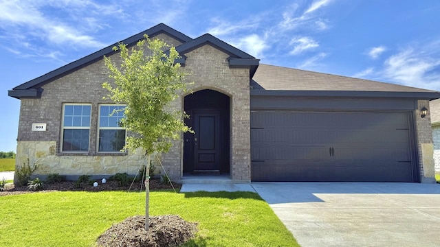 601 Banks Pl, Josephine, TX 75135 - view of front of house with concrete driveway, a garage, stone siding, and a front lawn