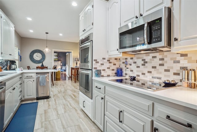 kitchen featuring light countertops, decorative backsplash, white cabinets, and stainless steel appliances