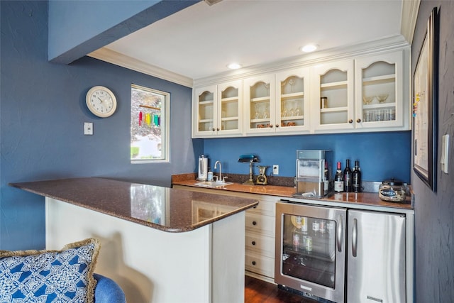 bar with a sink, wet bar, refrigerator, and beverage cooler