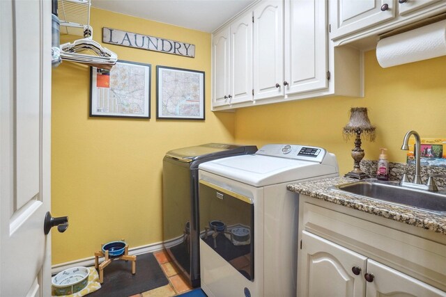 laundry room featuring a sink, baseboards, washing machine and dryer, and cabinet space