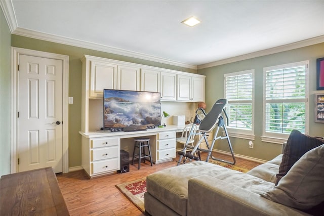 interior space with baseboards, crown molding, light wood finished floors, and built in desk