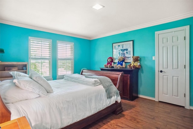 bedroom featuring crown molding, baseboards, and wood finished floors