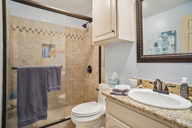 full bath with vanity, toilet, and a stall shower