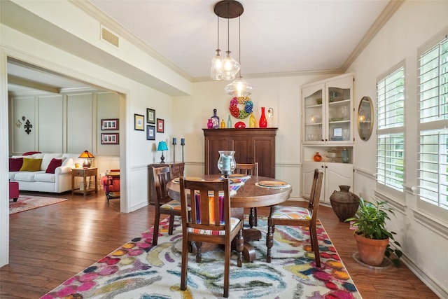 dining area featuring visible vents, wood-type flooring, and crown molding