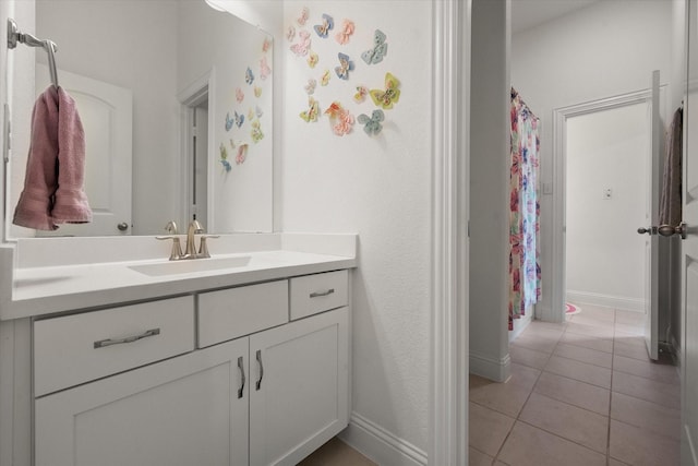 bathroom featuring vanity, baseboards, tile patterned flooring, and curtained shower