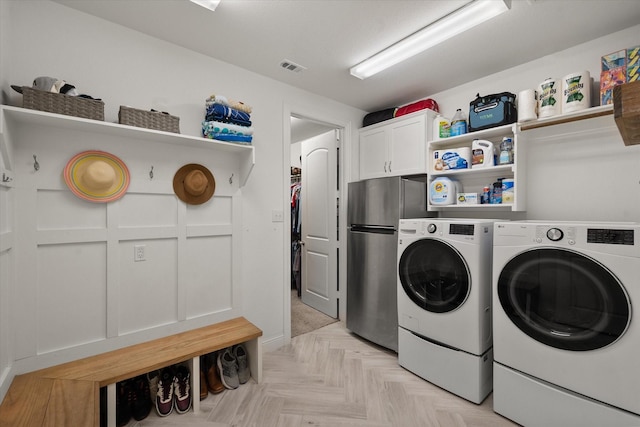 laundry room featuring visible vents, cabinet space, and washing machine and dryer