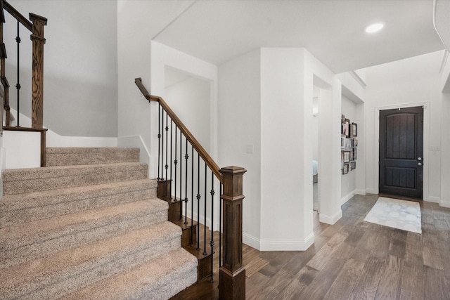 foyer with recessed lighting, baseboards, stairs, and wood finished floors