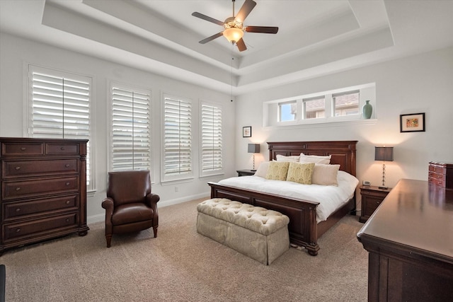 bedroom with carpet flooring, ceiling fan, and a raised ceiling