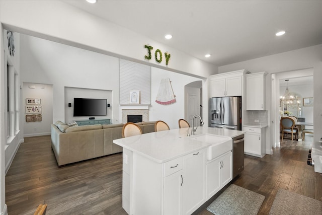 kitchen with dark wood-style flooring, appliances with stainless steel finishes, a sink, light countertops, and white cabinets