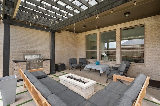 view of patio featuring grilling area, exterior kitchen, a pergola, and a fire pit