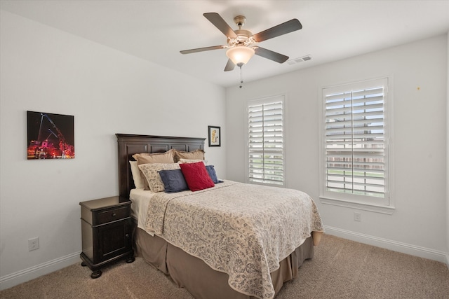 bedroom with baseboards, light colored carpet, and visible vents