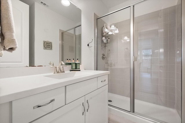 full bathroom featuring visible vents, vanity, and a shower stall