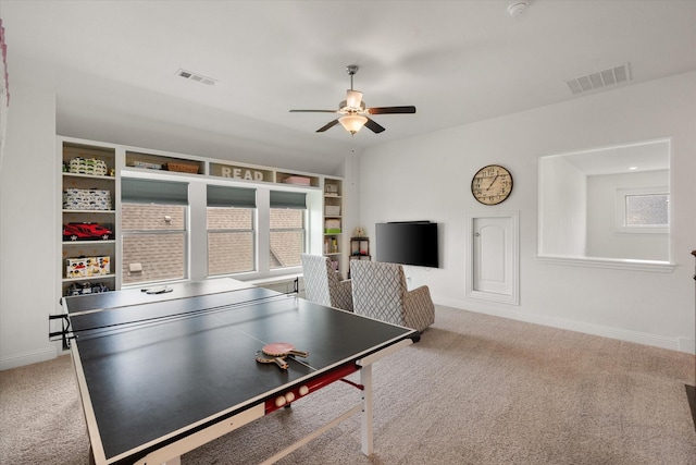 rec room with a ceiling fan, visible vents, a wealth of natural light, and carpet