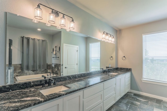 250 Beulah Rd, Millsap, TX 76066 - full bath featuring double vanity, baseboards, a sink, and a tub to relax in