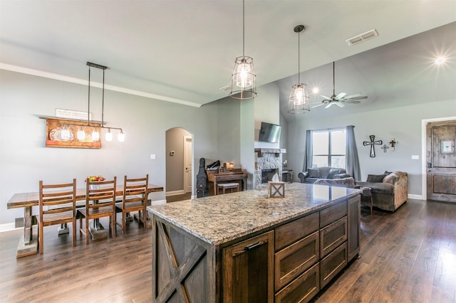 250 Beulah Rd, Millsap, TX 76066 - kitchen with visible vents, dark wood-style flooring, a stone fireplace, ceiling fan, and arched walkways
