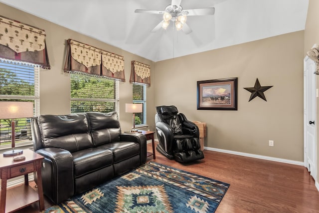 living area with a wealth of natural light, baseboards, wood finished floors, and a ceiling fan