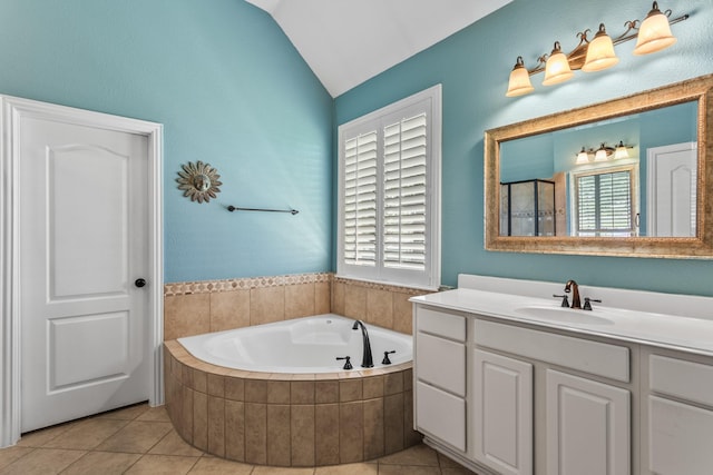 full bath featuring vaulted ceiling, tile patterned flooring, a garden tub, and vanity