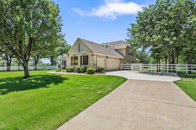 view of front of property with fence, stone siding, driveway, a garage, and a front lawn
