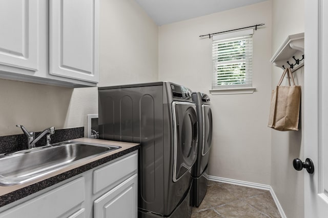 laundry area featuring washer and clothes dryer, cabinet space, baseboards, and tile patterned floors