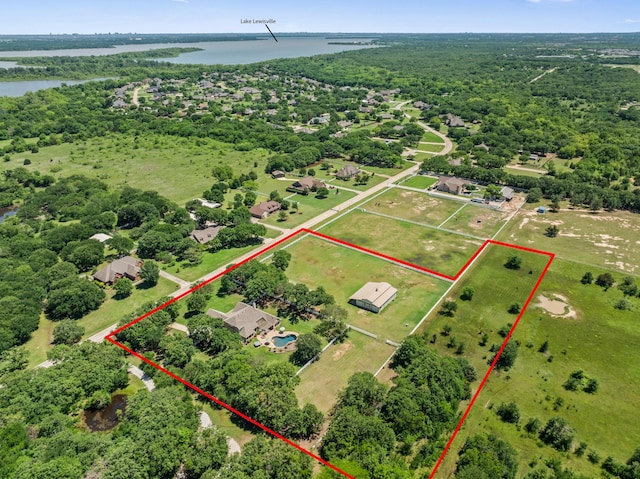 aerial view of property's location with a nearby body of water, property parcel outlined, and a forest
