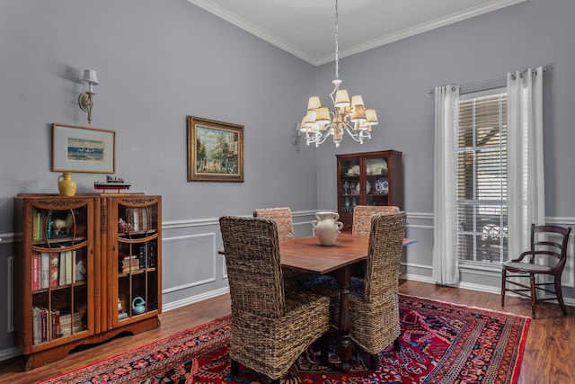 dining room featuring ornamental molding, a notable chandelier, and wood finished floors