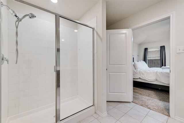 ensuite bathroom featuring tile patterned flooring, baseboards, connected bathroom, and a stall shower