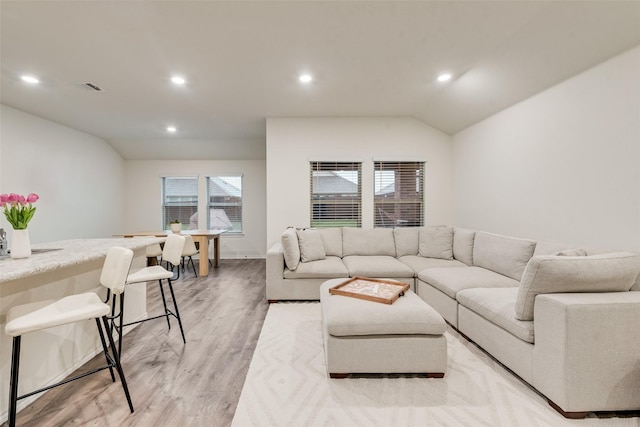 living room with recessed lighting, visible vents, light wood-style flooring, and lofted ceiling