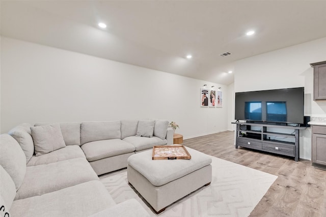 living area with visible vents, vaulted ceiling, baseboards, recessed lighting, and light wood-style flooring