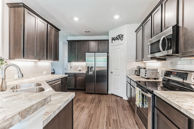 3225 Sweetwater Way, Sherman, TX 75090 - kitchen with dark brown cabinets, a sink, light countertops, stainless steel appliances, and tasteful backsplash