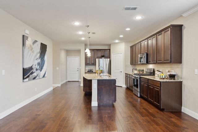 6281 Paragon Dr, Frisco, TX 75036 - kitchen featuring dark brown cabinets, light stone counters, stainless steel appliances, recessed lighting, and visible vents