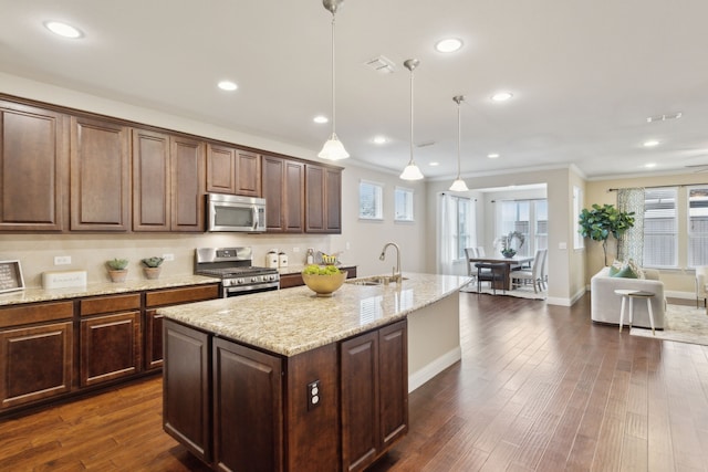 6281 Paragon Dr, Frisco, TX 75036 - kitchen featuring crown molding, light stone countertops, a center island with sink, a sink, and stainless steel appliances
