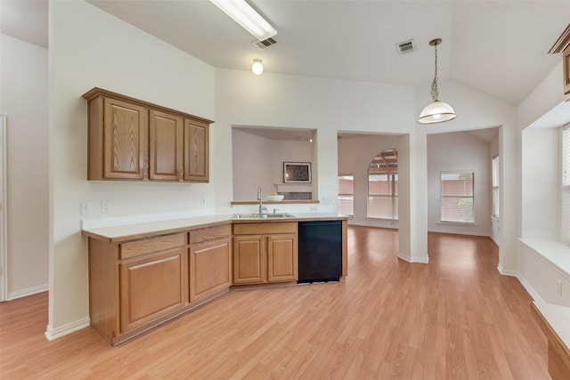 kitchen with vaulted ceiling, a sink, light countertops, black dishwasher, and light wood-style flooring