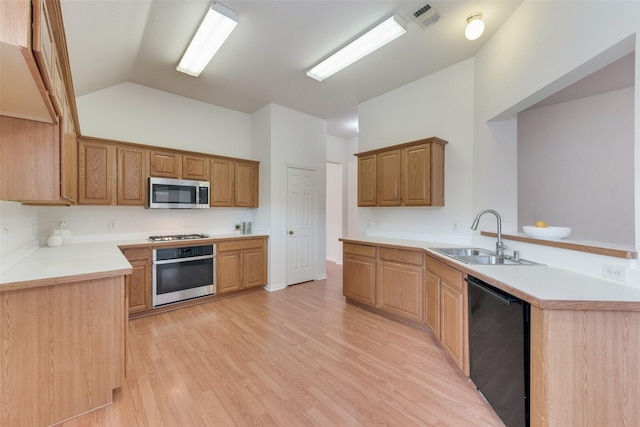 kitchen with visible vents, a peninsula, lofted ceiling, a sink, and appliances with stainless steel finishes
