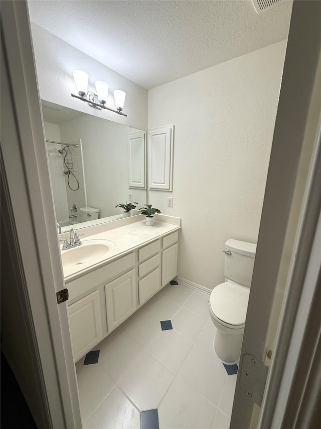 bathroom with tile patterned flooring, double vanity, toilet, a textured ceiling, and a sink