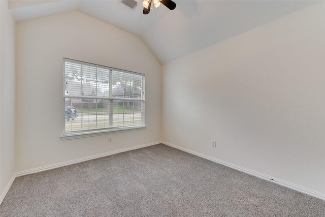 carpeted empty room with visible vents, a ceiling fan, baseboards, and vaulted ceiling