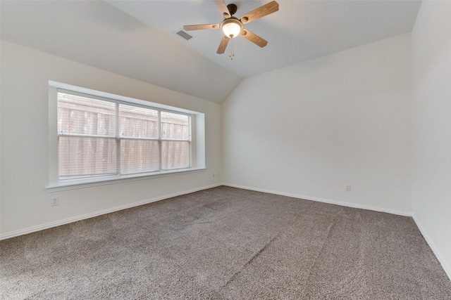 carpeted empty room featuring visible vents, a ceiling fan, baseboards, and vaulted ceiling