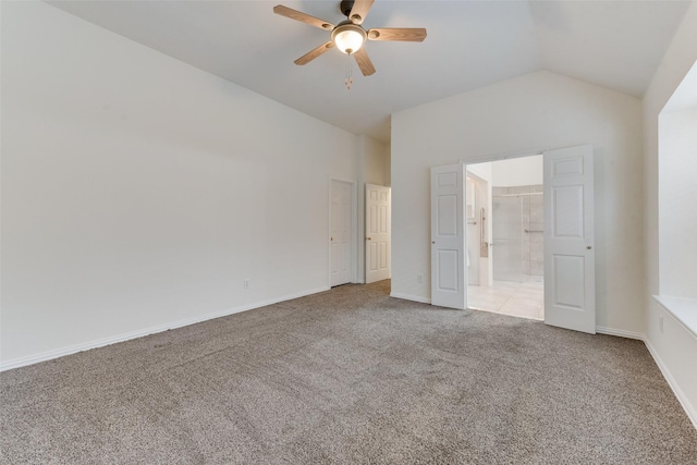 unfurnished bedroom featuring light carpet, baseboards, ceiling fan, connected bathroom, and vaulted ceiling