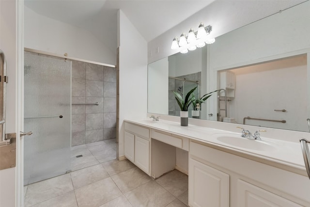 full bath featuring double vanity, a sink, tile patterned floors, and a tile shower