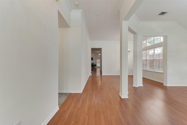 entrance foyer with baseboards, ornamental molding, light wood-type flooring, and visible vents