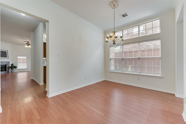 unfurnished dining area featuring crown molding, visible vents, a wealth of natural light, and light wood finished floors