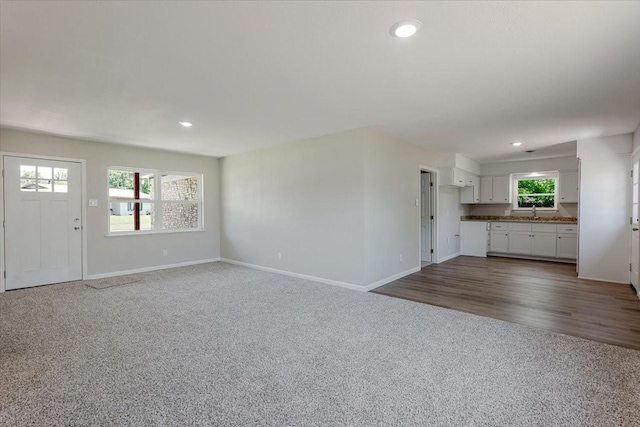 1017 SE 21st St, Mineral Wells, TX 76067 - unfurnished living room with dark carpet, recessed lighting, baseboards, and a sink